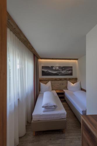 a bedroom with two beds and a window at The Lodge by Regina in Sölden