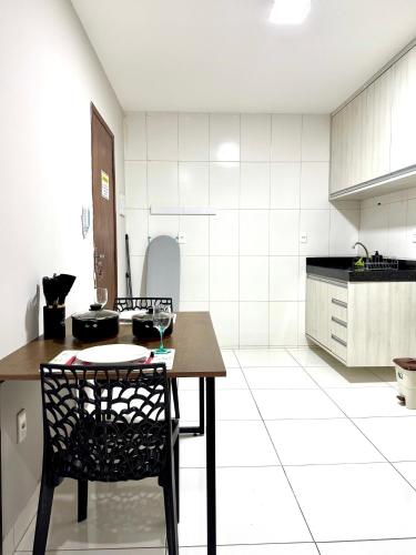 a kitchen with a table and chairs in a room at Studio Charmoso e Aconchegante em Itaberaba II in Itaberaba