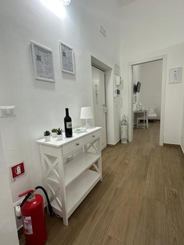 a white room with a white table with a bottle of wine at Apulia White House 59 in Bari