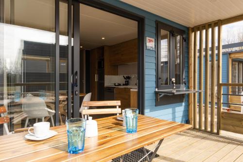 a wooden table on a deck with a kitchen at Boje 73 in Scharbeutz