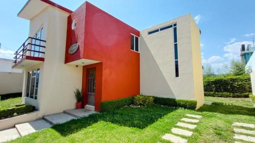 una casa con un'arancia e un bianco di Casa privada a 5min del Puente de cristal con terraza, BBQ, jardín y parking a Zacatlán