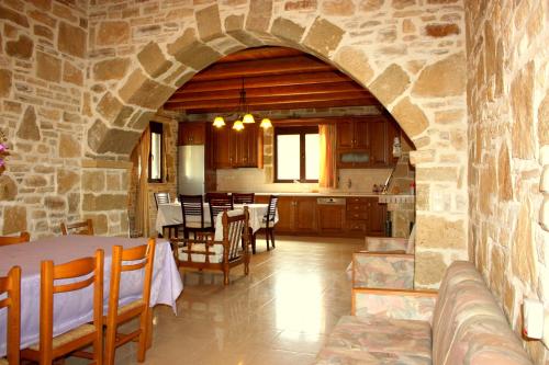 eine Küche und ein Wohnzimmer mit einer Steinmauer in der Unterkunft Villa Fabrika in Vóroi