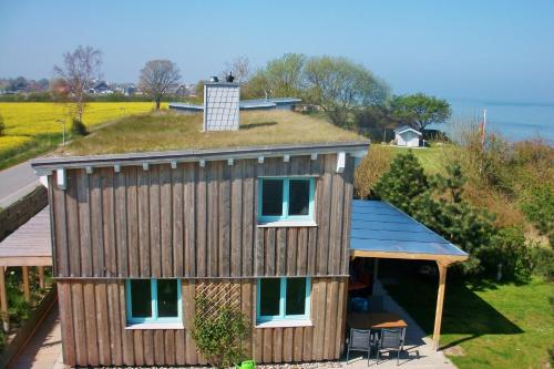 a house with a grassy roof with a small house at Strandhus Mira in Dahme