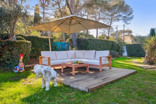- un canapé blanc, une table et un parasol dans l'établissement Villa avec pisicne proche Mer Fréjus 8 pers, à Fréjus