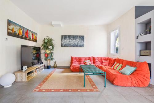 un salon avec un canapé rouge et une télévision dans l'établissement Villa avec pisicne proche Mer Fréjus 8 pers, à Fréjus