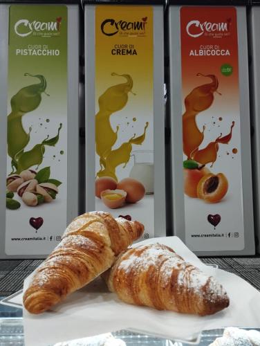 two boxes of fresh bread and croissants on a plate at Profumo di casa in Lascari