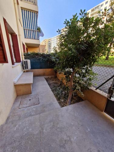 un trottoir avec un arbre et un bâtiment dans l'établissement appartement 2 pégurier, à Nice