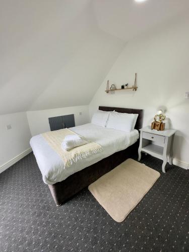 a bedroom with a bed and a table with a stool at Cosy 3 Bed Apartment Near Birmingham Airport & NEC Perfect for Groups & Contractors! in Birmingham