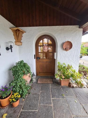 a front door of a house with potted plants at Ferienwohnung - Apartment Sabine - Urlaub mit Hund in Peiting