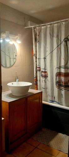 La salle de bains est pourvue d'un lavabo et d'une baignoire avec rideau de douche. dans l'établissement 90m2 3ch duplex cœur village 10 mn piste free navette, à Bolquère-Pyrénées 2000