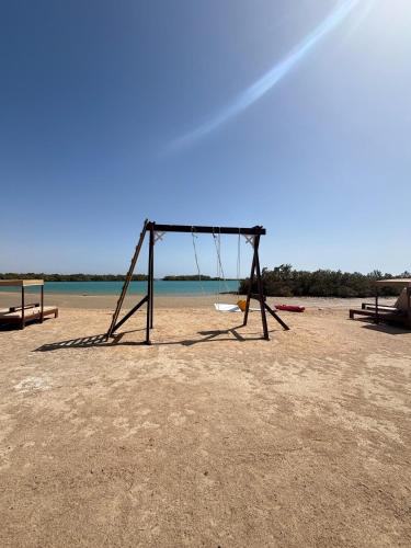 an empty swing set on a sandy beach at Mangrove Camp in Sharm El Sheikh