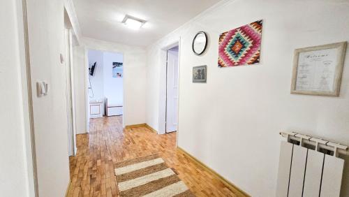 a hallway with white walls and a clock on a wall at Holiday Home Old Town in Sarajevo