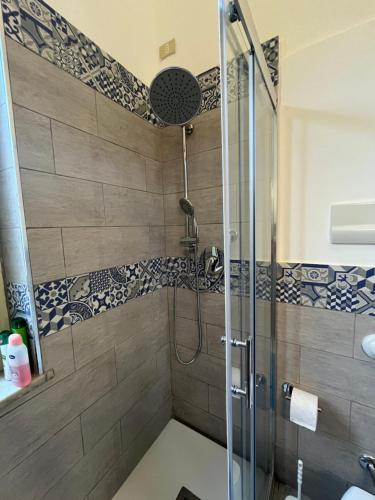 a shower with a glass door in a bathroom at Vito's holiday house in Palermo