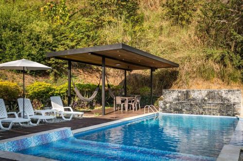 a pool with a gazebo and chairs and a table and a pool at Monteclaro Campestre - En Sopetran in Sopetran