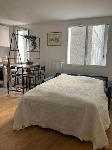 une chambre avec un lit, une table et des chaises dans l'établissement New cozy studio near Roland Garros and Parc des Princes, à Boulogne-Billancourt