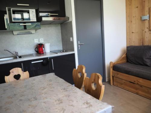 une petite cuisine avec une table et un canapé dans l'établissement Résidence Median - Studio rénové · Proche des pistes · Balcon MAE-1764, aux Menuires