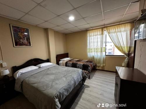 a hotel room with two beds and a window at Hotel 4 Rios in Cuenca