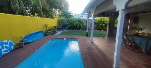 a swimming pool on a deck next to a house at Maison Centre-ville Mer à pied in Saint-François