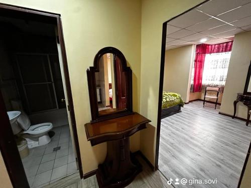 a bathroom with a mirror and a sink and a toilet at Parking Hotel 4 Rios in Cuenca
