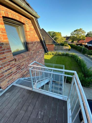 a shopping cart on a deck next to a house at Küstenbutze im modernen Style mit Balkon in Mildstedt