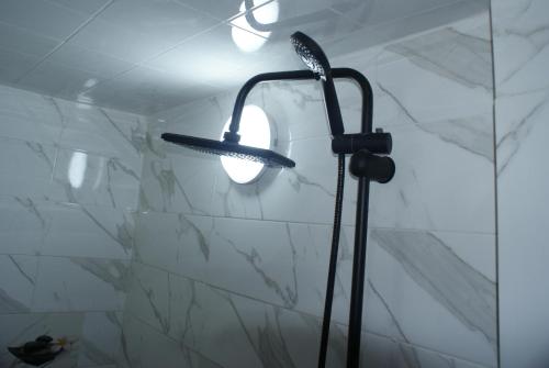 a shower light in a bathroom with a marble wall at Magnifique chambre à prix inedit in Agadir