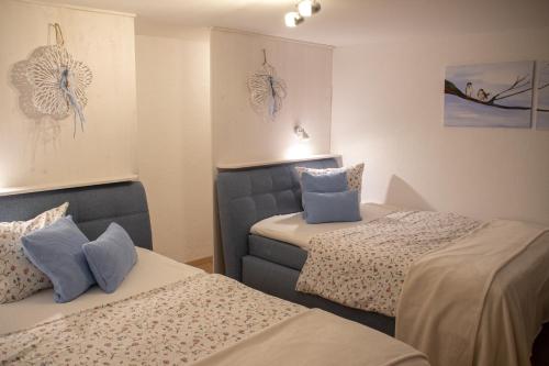 two beds in a room with blue pillows at Hof Timmermann - Spatzennest in Ottenstein