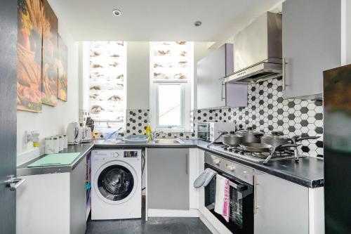 a kitchen with a washing machine and a washer at -RA83- For your relaxed,Cosy stay,Free Parking in Leeds