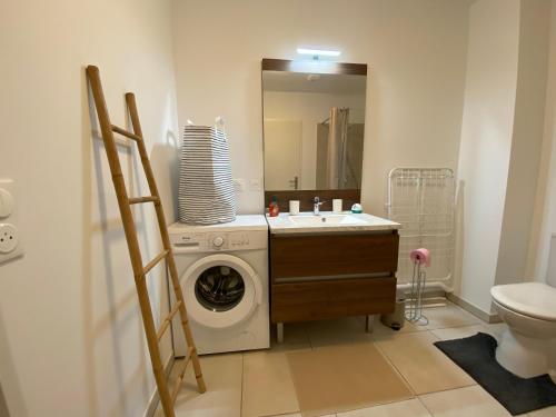 une salle de bain avec une machine à laver et un lavabo dans l'établissement Appartement Côté Dune à 600m de l'Océan, à Mimizan-Plage