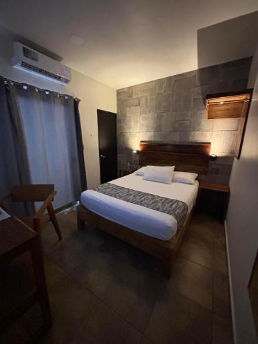 a bedroom with a bed and a stone wall at 15 AVENIDA in Tapachula