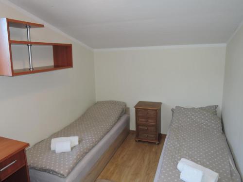 a bedroom with two beds and a wooden table at Holiday Home near Baltic Sea & Sandy Beaches in Międzyzdroje