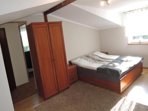 a bedroom with a bed and a wooden cabinet at Holiday Home near Baltic Sea & Sandy Beaches in Międzyzdroje