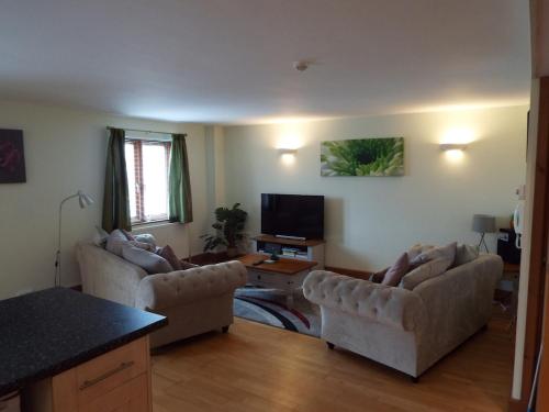 a living room with two couches and a tv at Marina View in Milford Haven