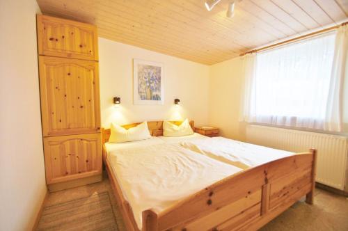 Un dormitorio con una cama grande y una ventana. en Ferienbungalow 3, en Dahme