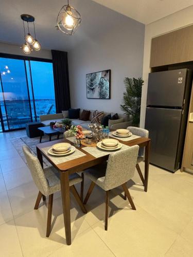 a kitchen and living room with a wooden table and chairs at Monthly Only, 1BR Aprt,Beach Access,Garden View in Amwaj Island