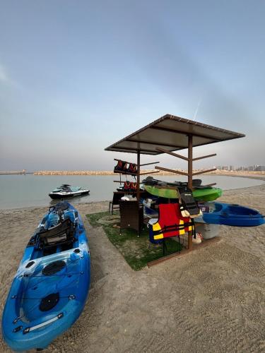 a group of kayaks and a shelter on the beach at Monthly Only, 1BR Aprt,Beach Access,Garden View in Amwaj Island