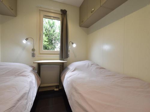 two beds in a room with a window and a sink at Stylish Stay in Vorden Woods in Vorden