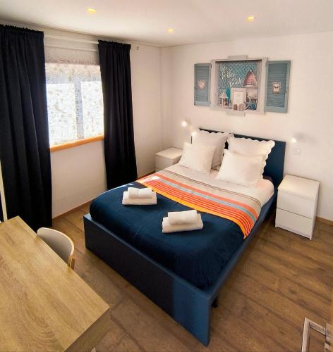 a bedroom with a bed with two towels on it at Herama Sea Guesthouse in Vila Nova de Gaia