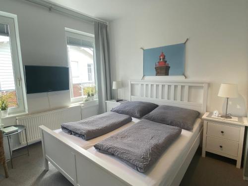a bedroom with a bed with two pillows on it at Haus AchternDiek Strandvogel in Dahme