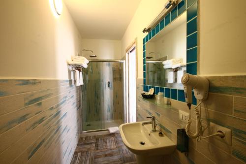 a bathroom with a sink and a toilet at Hotel Muita di Mari in Santa Teresa Gallura