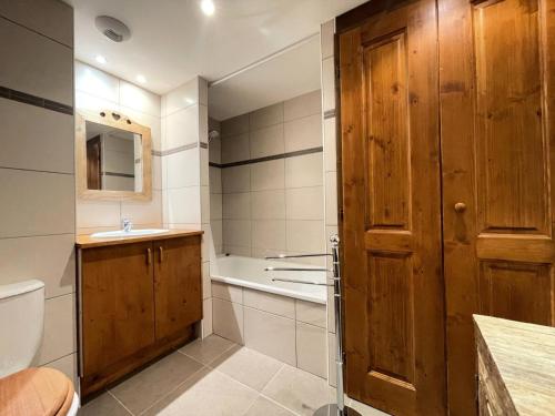 une salle de bain avec toilettes et porte en bois dans l'établissement Résidence Les Logis De Bellecombe - Appartement de charme proche des pistes et du centre MAE-5251, à Notre-Dame-de-Bellecombe