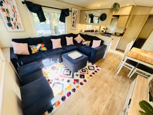 a living room with a blue couch and a rug at 3 Bedroom Caravan LG3, Lower Hyde, Shanklin in Shanklin