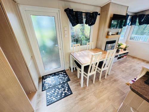 a kitchen and dining room with a table and chairs at 3 Bedroom Caravan LG3, Lower Hyde, Shanklin in Shanklin
