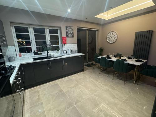 a kitchen and dining room with a table and a clock at Luxury 3bed Hot Tub and sauna facilities amazing location in Birmingham