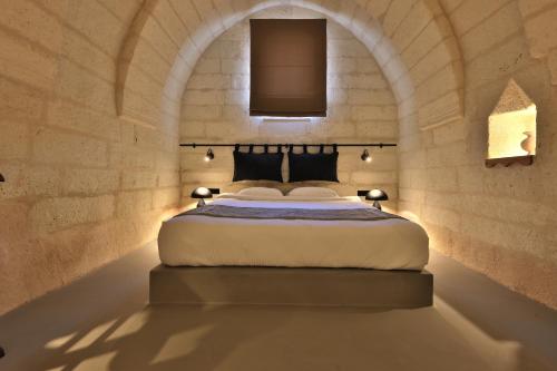 a bedroom with a bed in a stone wall at Simurg Cave House in Urgup