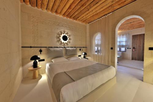 a bedroom with a large bed with a wooden ceiling at Simurg Cave House in Urgup