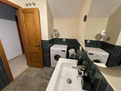 une salle de bain avec un lavabo et une laveuse et une sécheuse dans l'établissement Casa Dana El Cotillo with private terrace, à El Cotillo