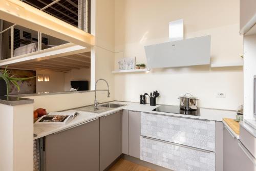 Una cocina con gabinetes blancos y un fregadero. en Apartment in the old town of Como - MonicaComoApartment, en Como