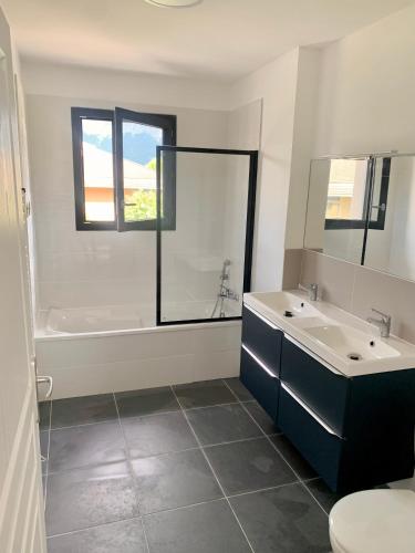 une salle de bain avec deux lavabos et une baignoire et des toilettes dans l'établissement 5mn Crolles Chambre au calme parking gratuit - belle cuisine partagée, à Froges