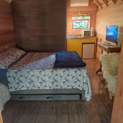 a bedroom with a bed and a desk in a cabin at Cabana em gramado in Gramado