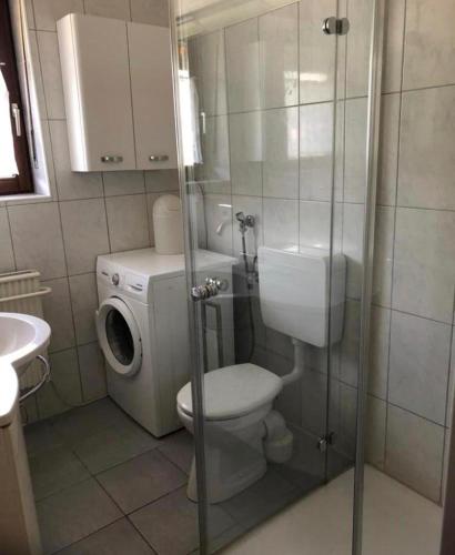 a bathroom with a toilet and a washing machine at Bungalow 6060 in Tossens in Tossenserdeich